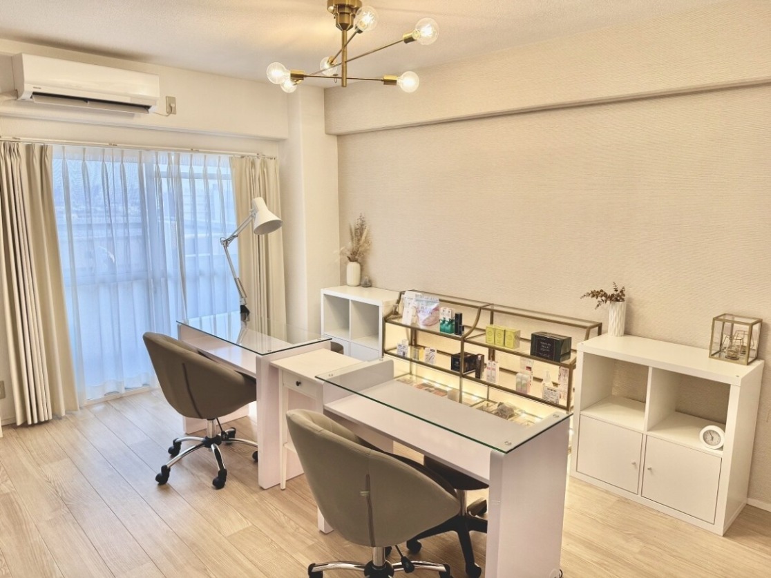白いカーテンとガラスのネイルデスクが並ぶ、明るいsalon teteの店内